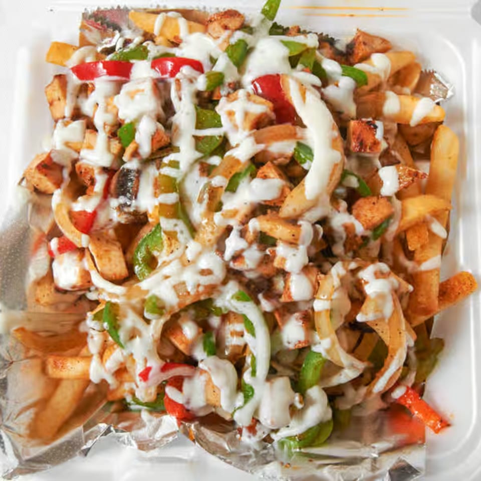 Dale's Deli loaded fries with chicken, peppers, onions, and white sauce in a takeout container.
