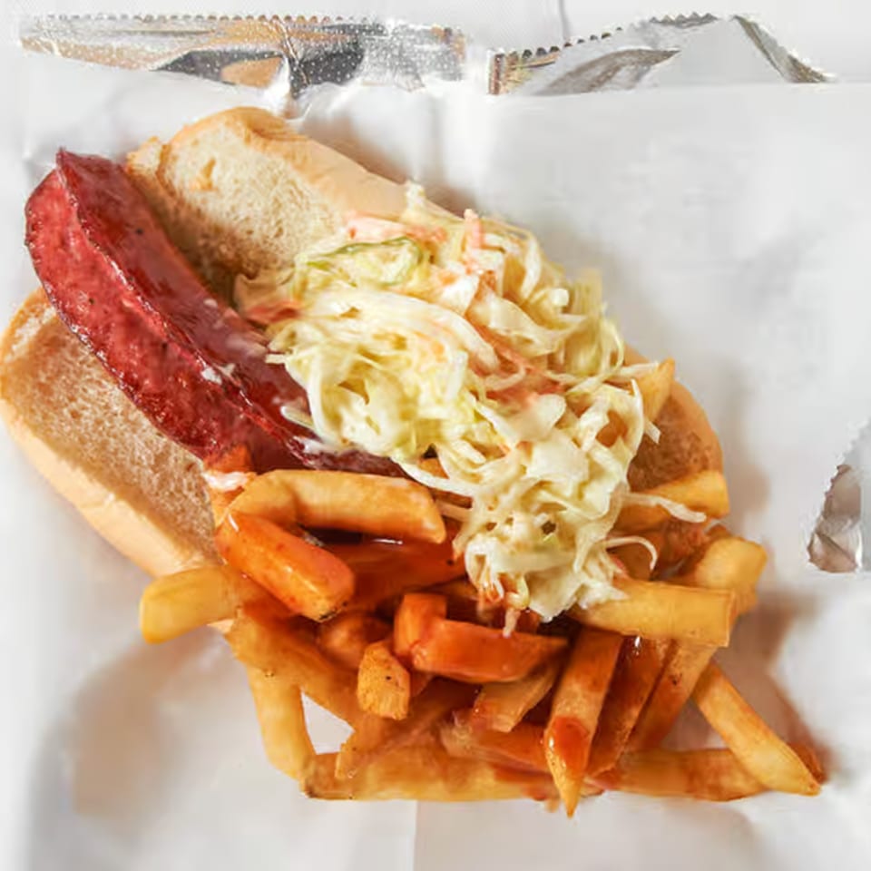 Dale's Deli hot dog with coleslaw and fries, served in a foil-lined basket.
