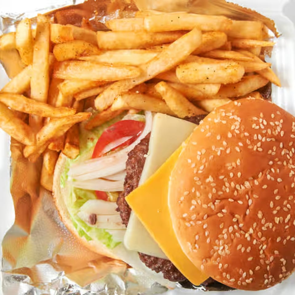 Dale's Deli cheeseburger with lettuce, tomato, onion, and a side of golden french fries.