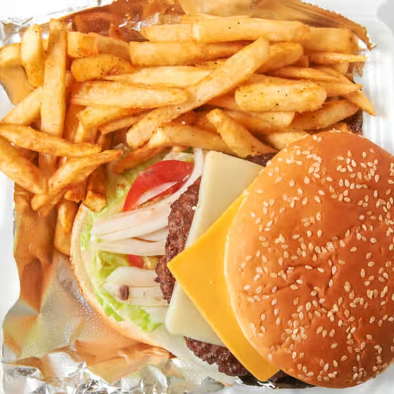 Dale's Deli cheeseburger with lettuce, tomato, onion, and a side of golden french fries.